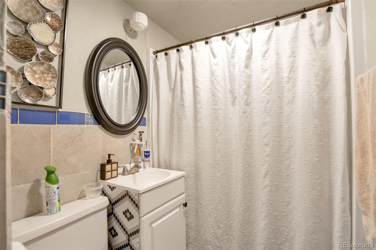 6830 Olive Street Commerce City, CO 80022 - Photo 16 of 25 a bathroom with a sink and a mirror