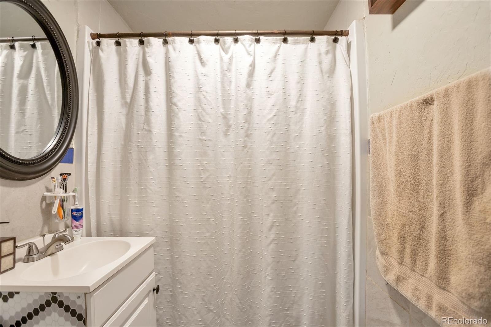6830 Olive Street Commerce City, CO 80022 - Photo 17 of 25 a bathroom with a sink and a mirror