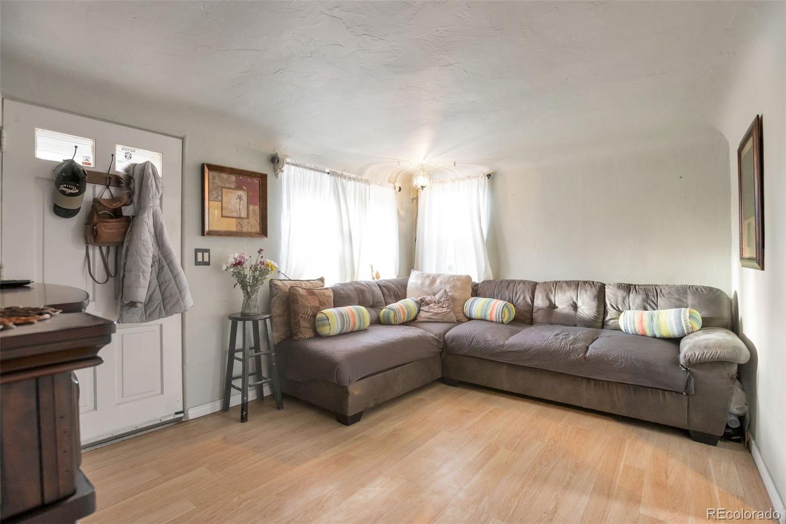 6830 Olive Street Commerce City, CO 80022 - Photo 3 of 25 a living room with furniture and a flat screen tv