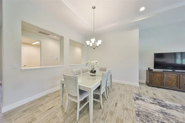 a dining room with furniture a chandelier and wooden floor