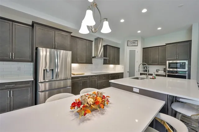a kitchen with stainless steel appliances a refrigerator sink and microwave