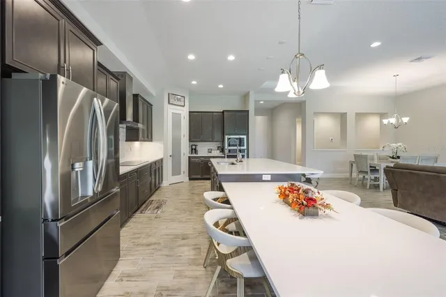 a large kitchen with a table chairs refrigerator and microwave
