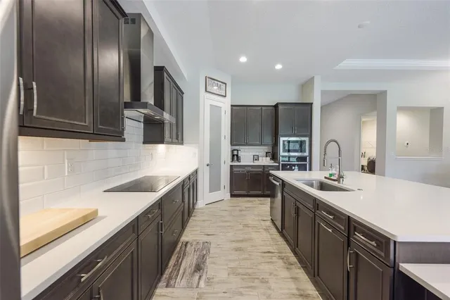 a large kitchen with stainless steel appliances granite countertop a sink stove refrigerator and cabinets