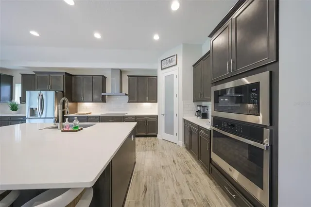 a kitchen with kitchen island granite countertop wooden cabinets a stove and a sink