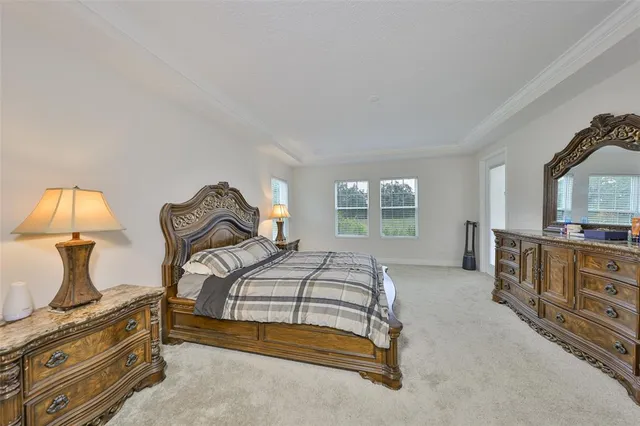 a bedroom with a bed and dresser with mirror