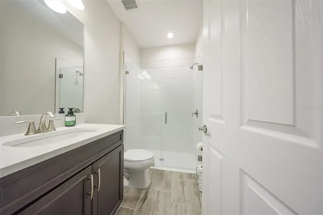 a bathroom with a sink a toilet a shower and a mirror