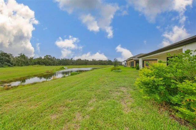a backyard of a house with lots of green space and lake view
