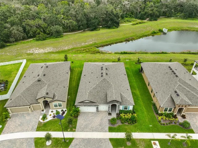 an aerial view of a house with a yard and lake view