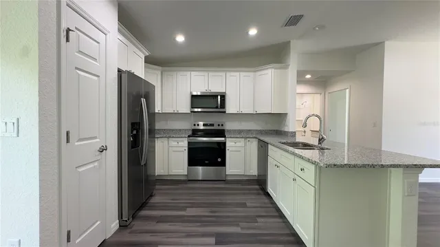 a kitchen with stainless steel appliances a refrigerator stove and sink