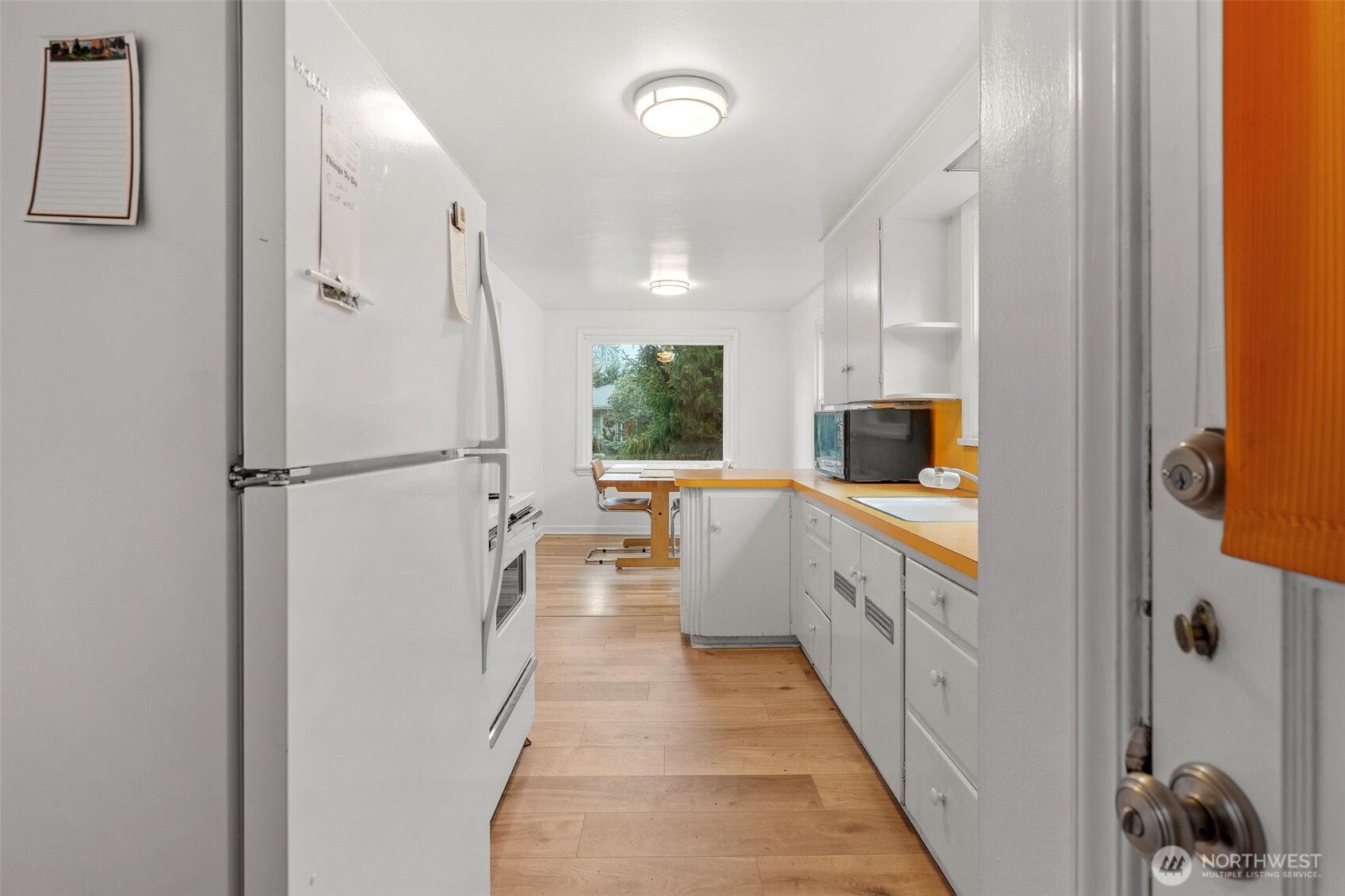9748 Dayton Avenue North Seattle, WA 98103 - Photo 11 of 39 a large white kitchen with a sink and refrigerator