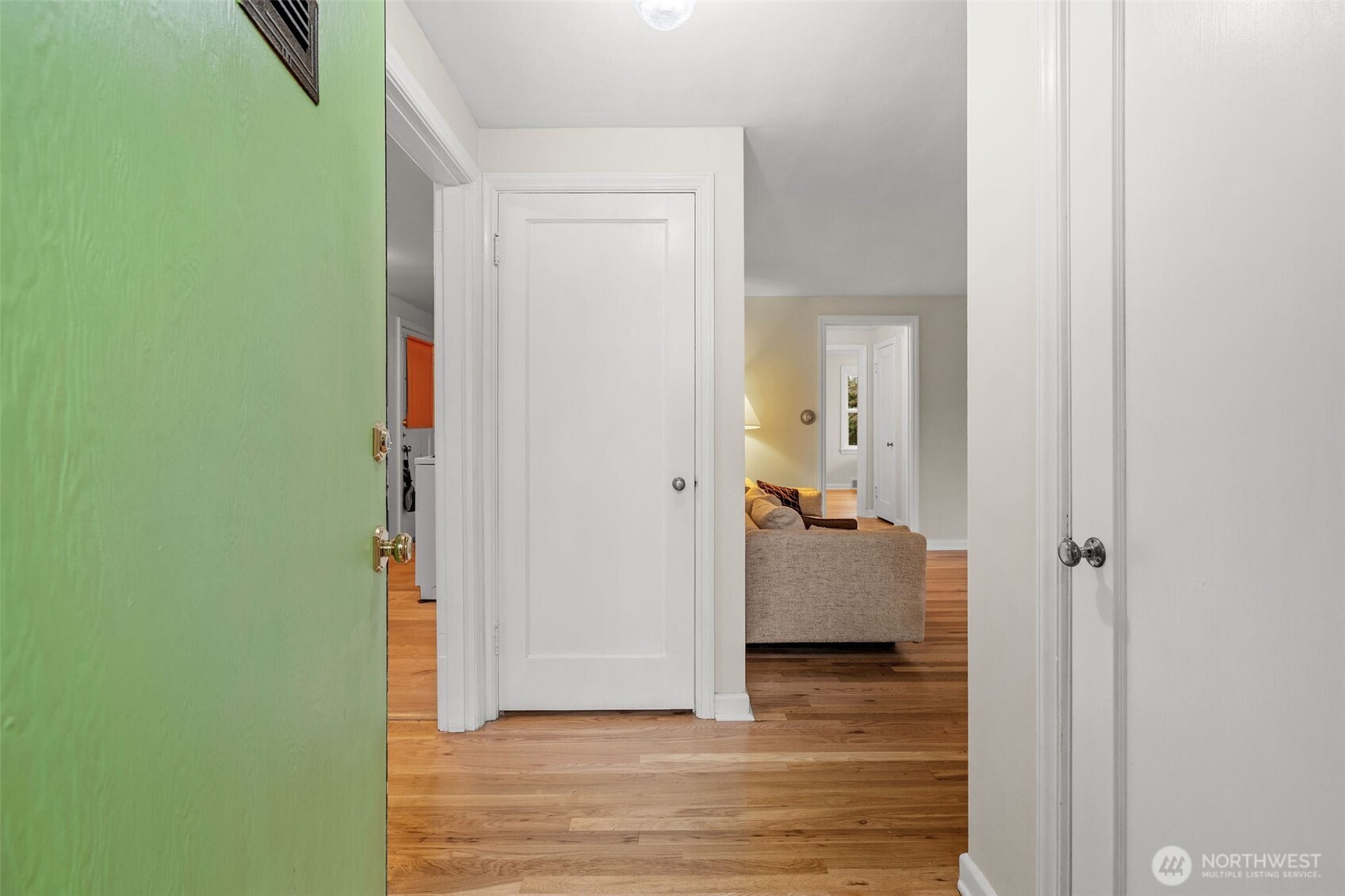 9748 Dayton Avenue North Seattle, WA 98103 - Photo 19 of 39 a view of a hallway with wooden floor and a livingroom