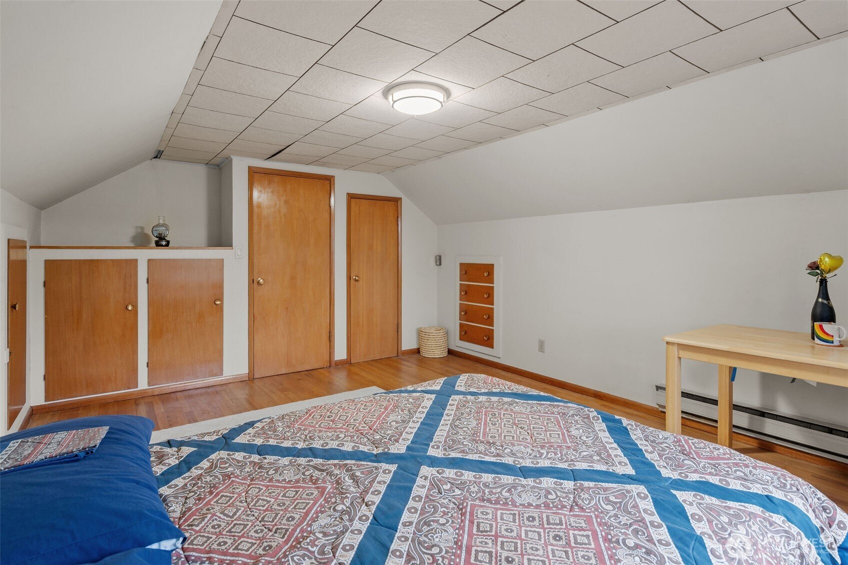9748 Dayton Avenue North Seattle, WA 98103 - Photo 22 of 39 a bedroom with a bed and wooden floor