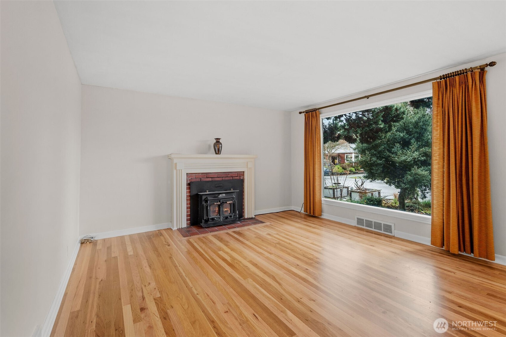 9748 Dayton Avenue North Seattle, WA 98103 - Photo 5 of 39 a view of an empty room with a fireplace and a window