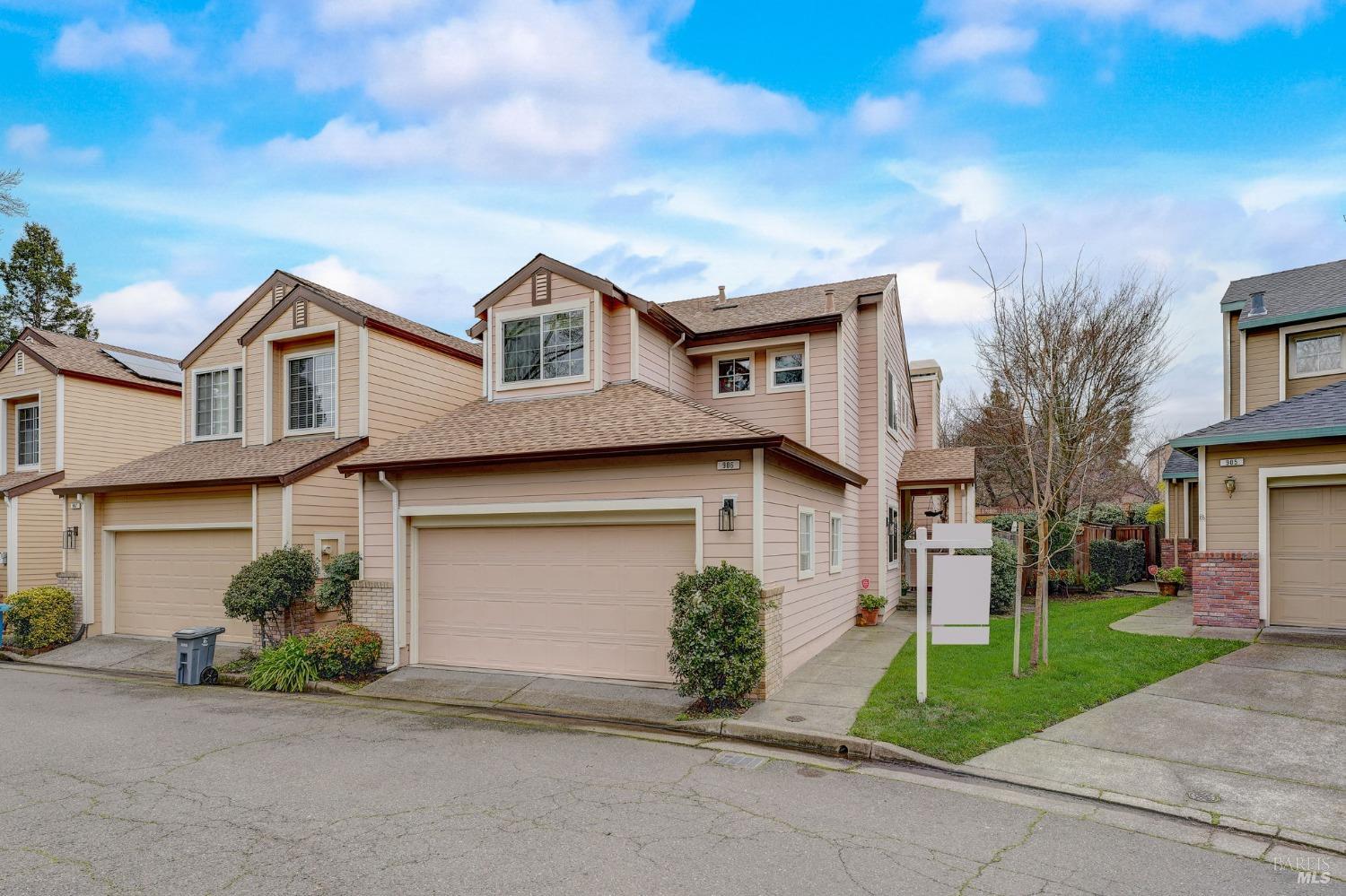 a front view of a house with a garden and trees