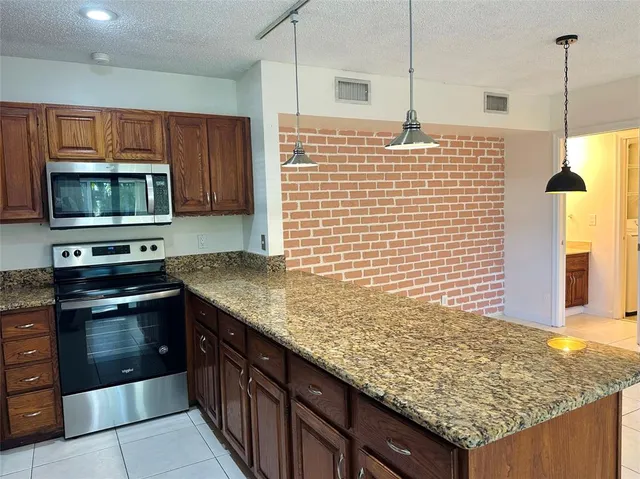 a kitchen with granite countertop sink and cabinets