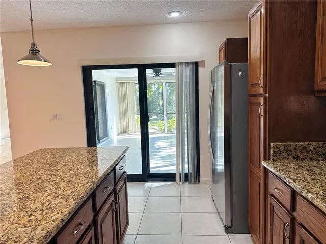 a kitchen with granite countertop a refrigerator and a sink