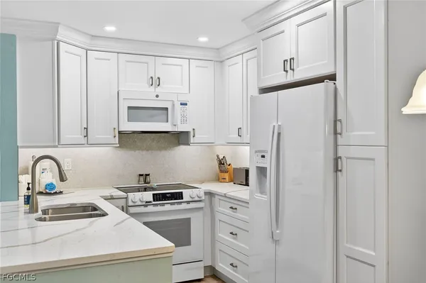 a kitchen with stainless steel appliances granite countertop white cabinets and refrigerator
