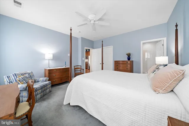 a spacious bedroom with a bed and ceiling fan