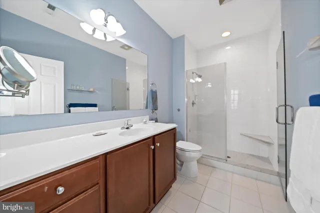a spacious bathroom with a shower sink mirror and toilet