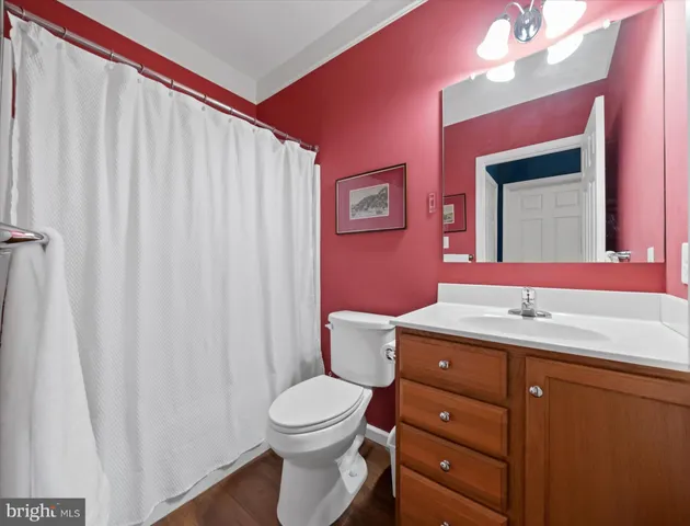 a bathroom with a toilet a sink and a mirror