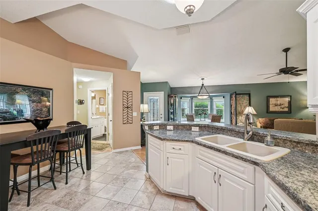a open kitchen with granite countertop a sink and chairs