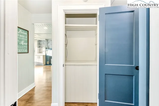 a view of a hallway with wooden floor and a living room