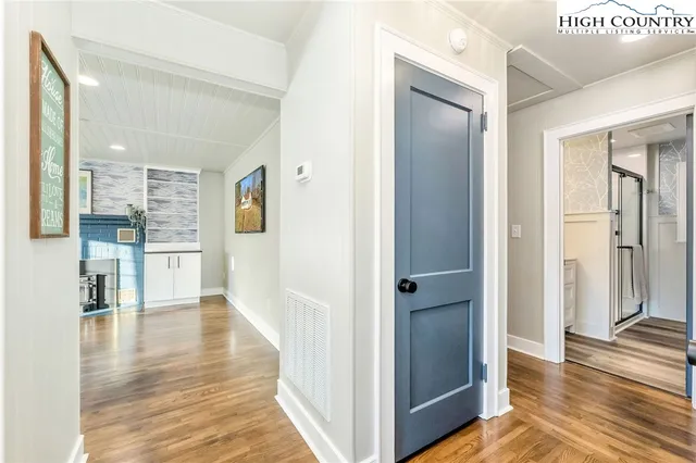 a view of a hallway with wooden floor and staircase
