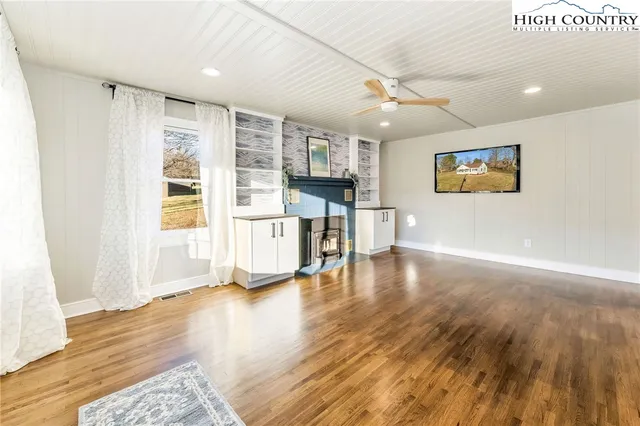 a view of empty room with wooden floor and window