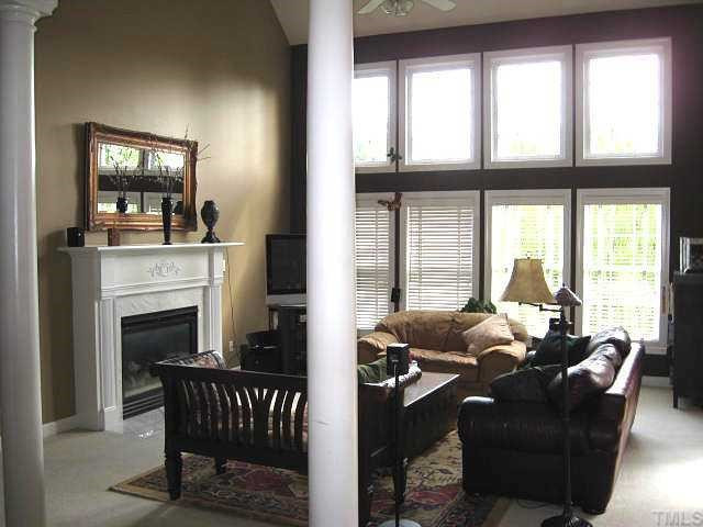 5136 Killarney Hope Drive Raleigh, NC 27613 - Photo 3 of 12 Two-story living room with double-tier windows & marble-surround gas log fireplace Living Room