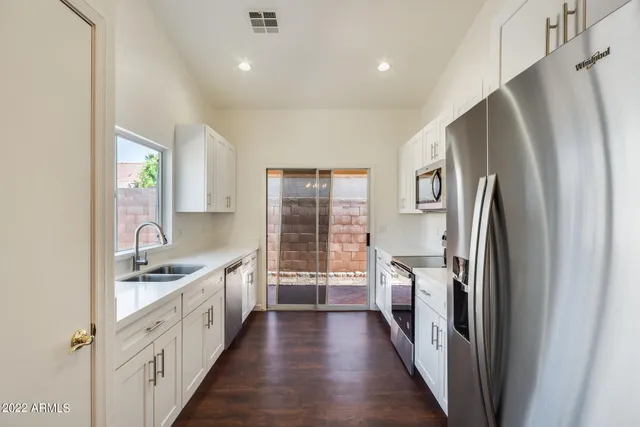 a kitchen with stainless steel appliances a refrigerator sink and cabinets