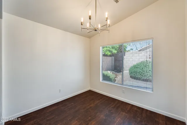 en empty room with wooden floor fan and window
