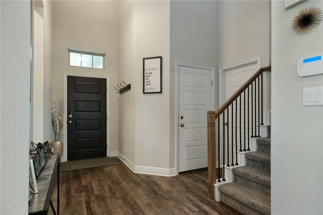 229 Bonnet Boulevard Georgetown, TX 78628 - Photo 4 of 20 Entryway featuring a towering ceiling, stairway, and dark wood-style floors