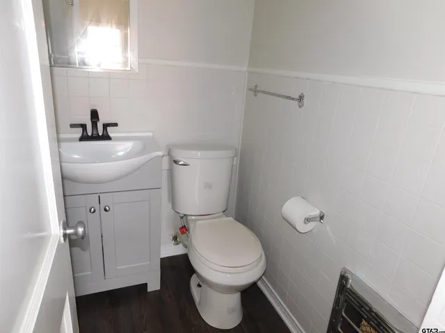a bathroom with a toilet sink and mirror