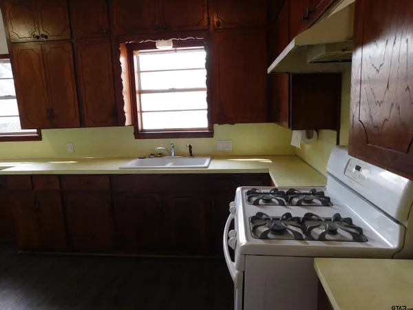a kitchen with a sink a stove and a microwave