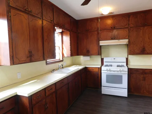 a kitchen with stainless steel appliances granite countertop a sink a stove and a refrigerator