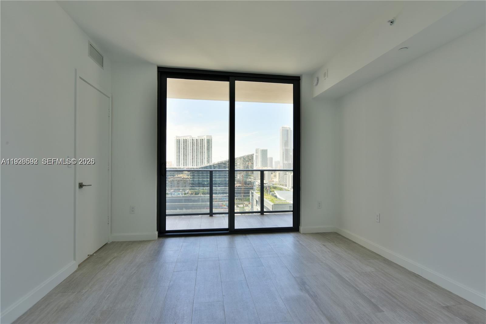 45 Southwest 9th Street, Unit 2209 Miami, FL 33130 - Photo 11 of 31 wooden floor in an empty room with a window