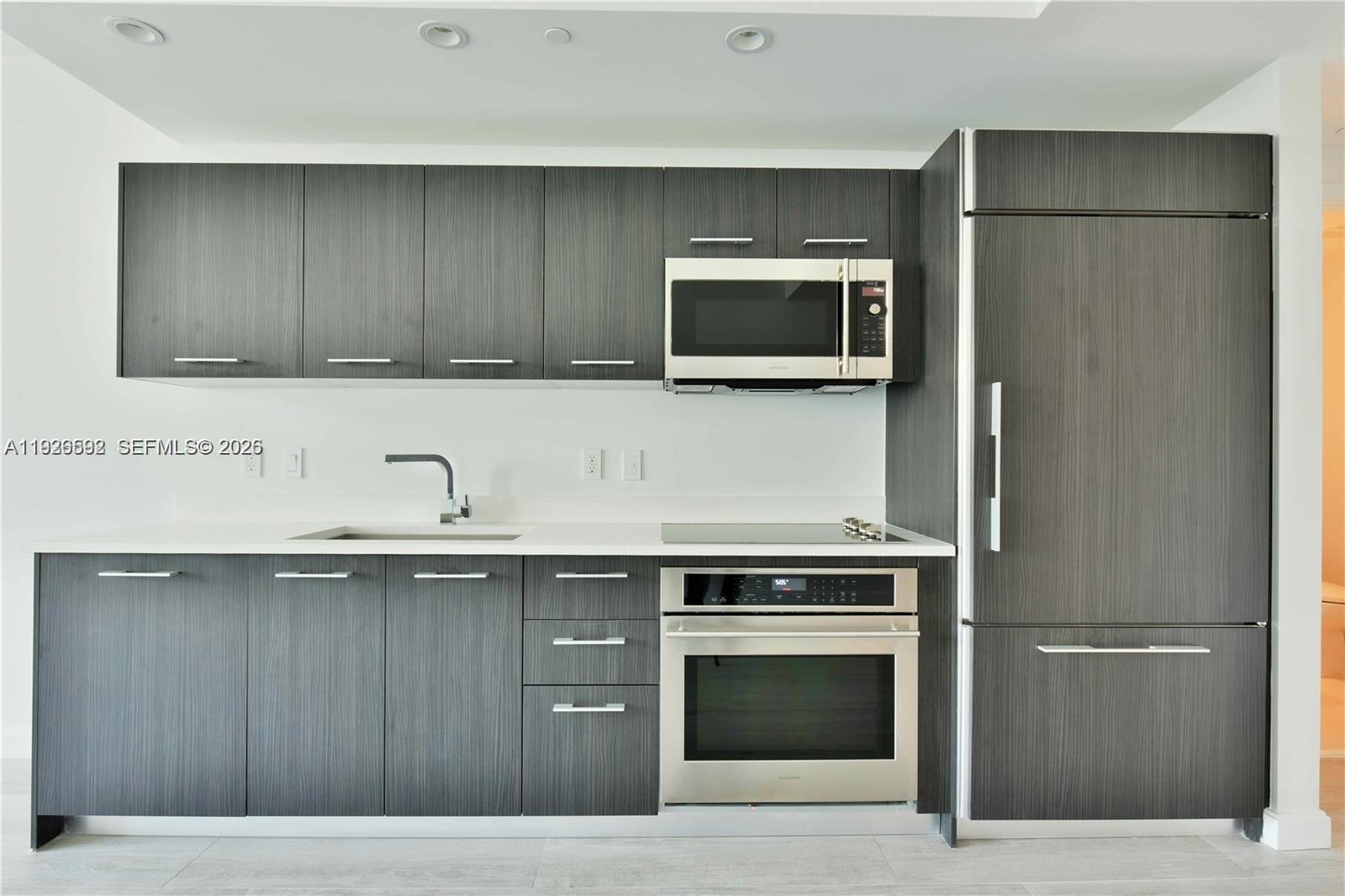 45 Southwest 9th Street, Unit 2209 Miami, FL 33130 - Photo 3 of 31 a kitchen with a sink and a microwave