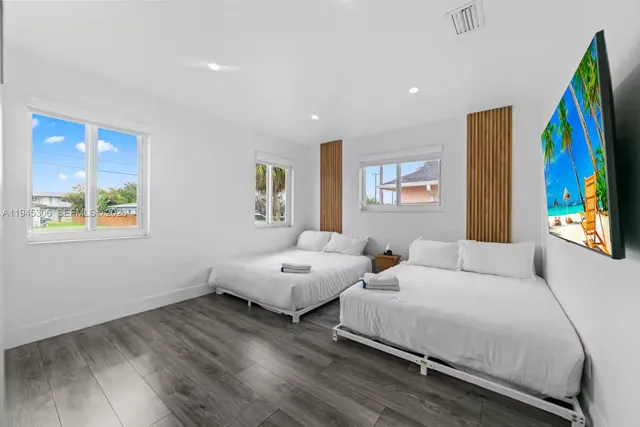 a spacious bedroom with two beds and painting on the wall