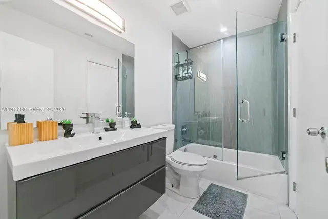 a bathroom with a double vanity sink toilet and shower