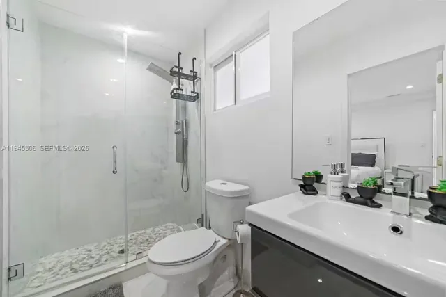 a bathroom with a sink a toilet and shower