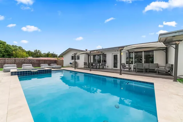 a view of a house with swimming pool and sitting area