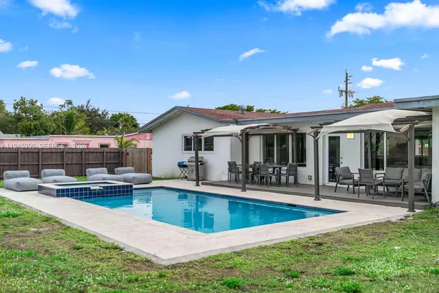 a view of a house with swimming pool and sitting area