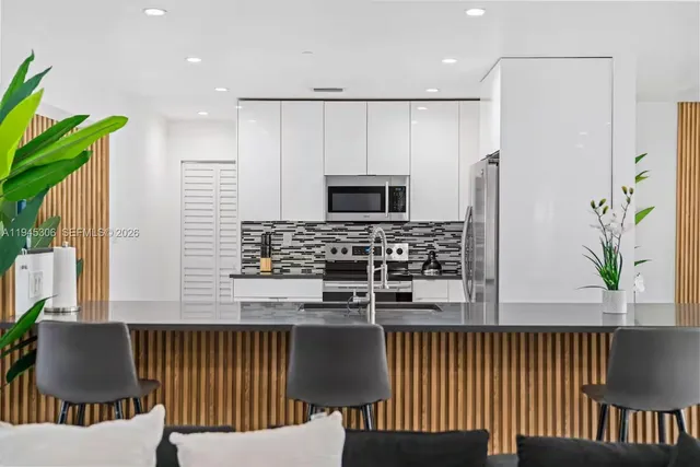 a kitchen with kitchen island stainless steel appliances a sink and a refrigerator