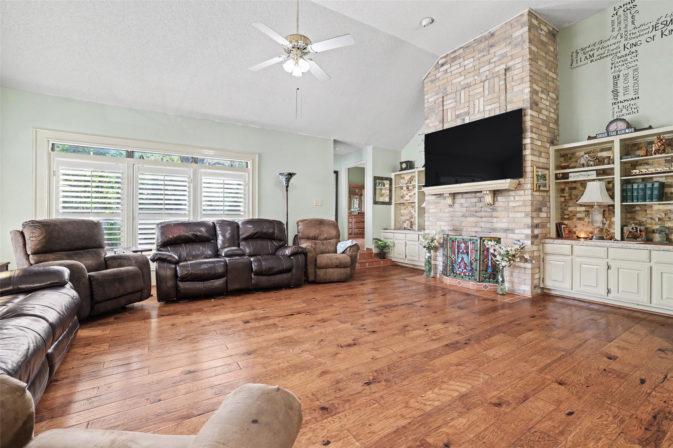 110 South Ridge Circle Georgetown, TX 78628 - Photo 5 of 37 Spacious living area featuring wood-finish flooring, a vaulted ceiling with a ceiling fan, and a large window with plantation shutters