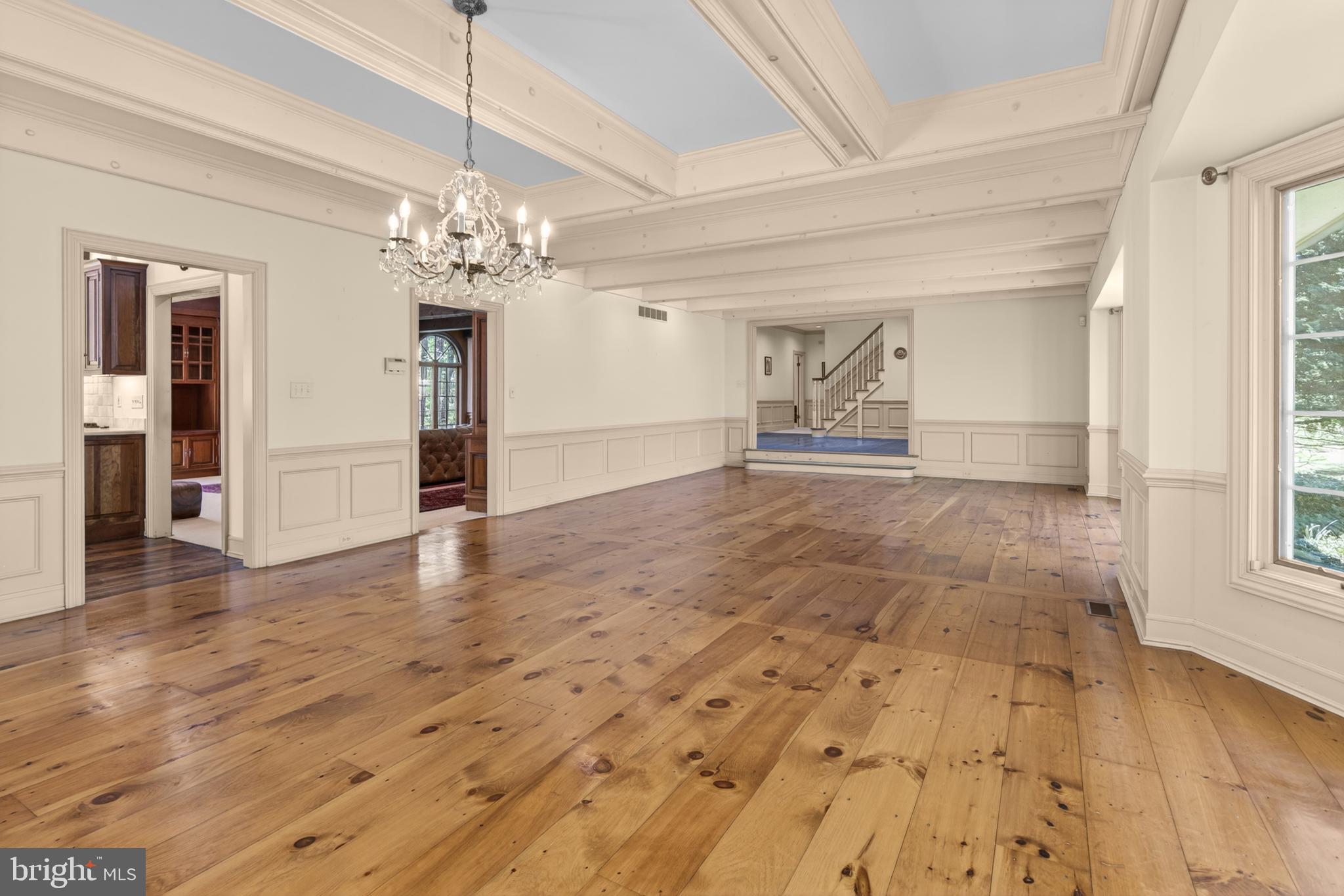 255 Arreton Road Princeton, NJ 08540 - Photo 15 of 65 an empty room with wooden floor chandelier and windows