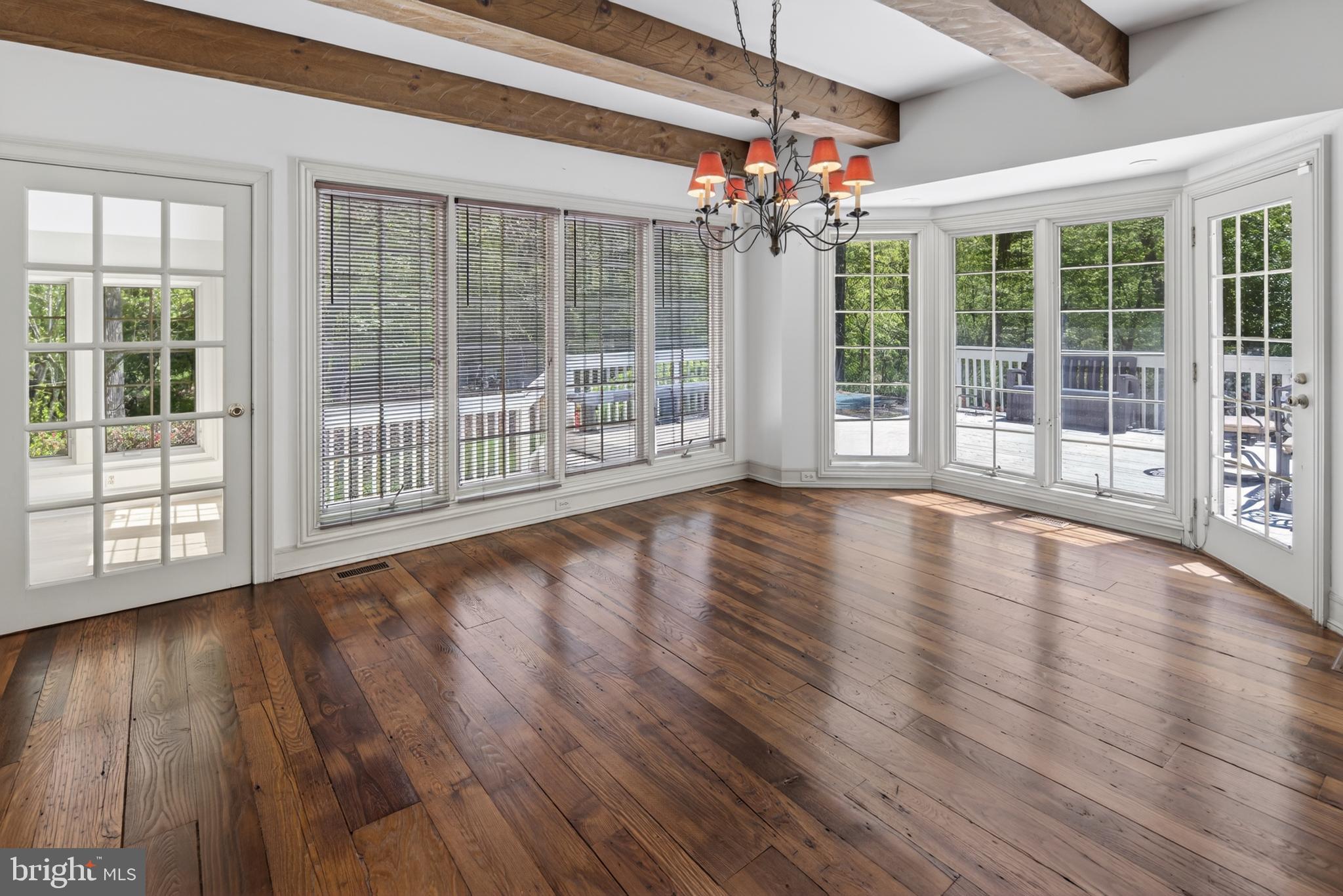 255 Arreton Road Princeton, NJ 08540 - Photo 22 of 65 a view of an empty room with wooden floor and a floor to ceiling window