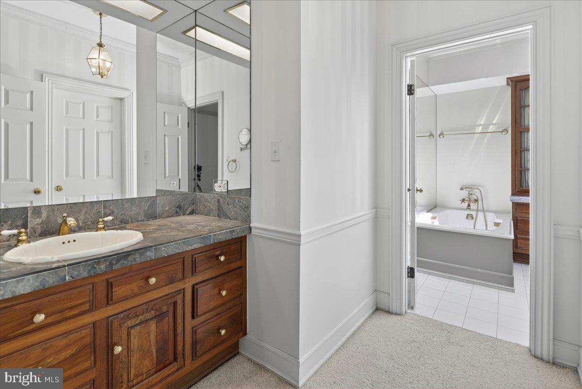 255 Arreton Road Princeton, NJ 08540 - Photo 34 of 65 a bathroom with a granite countertop sink and a mirror