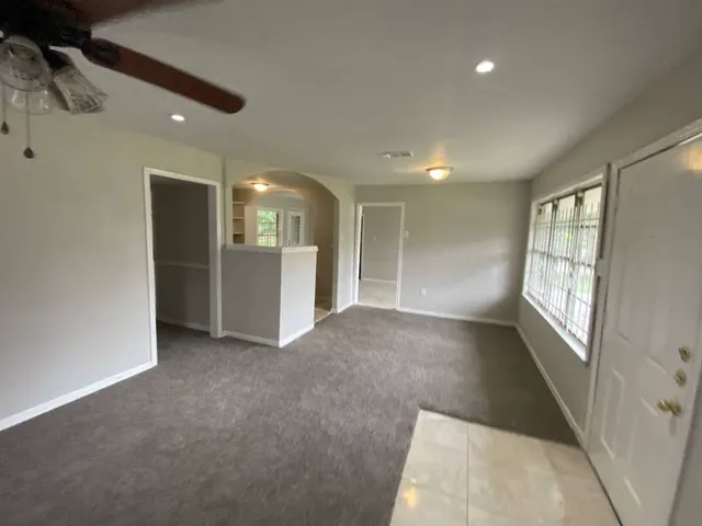 an empty room with windows and bathroom