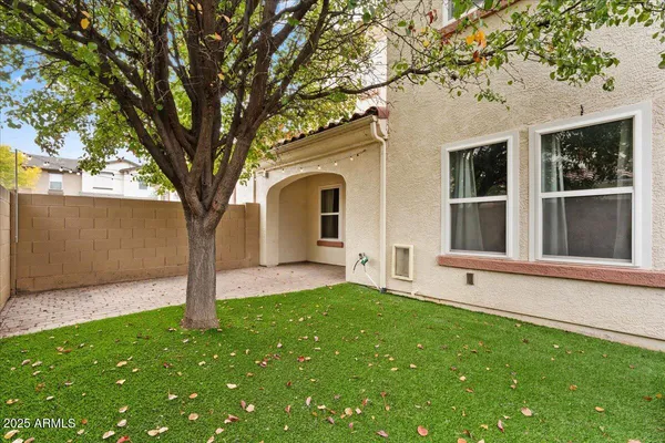 a front view of a house with a garden and tree