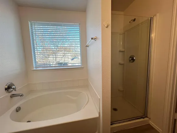 a white bath tub sitting next to a shower